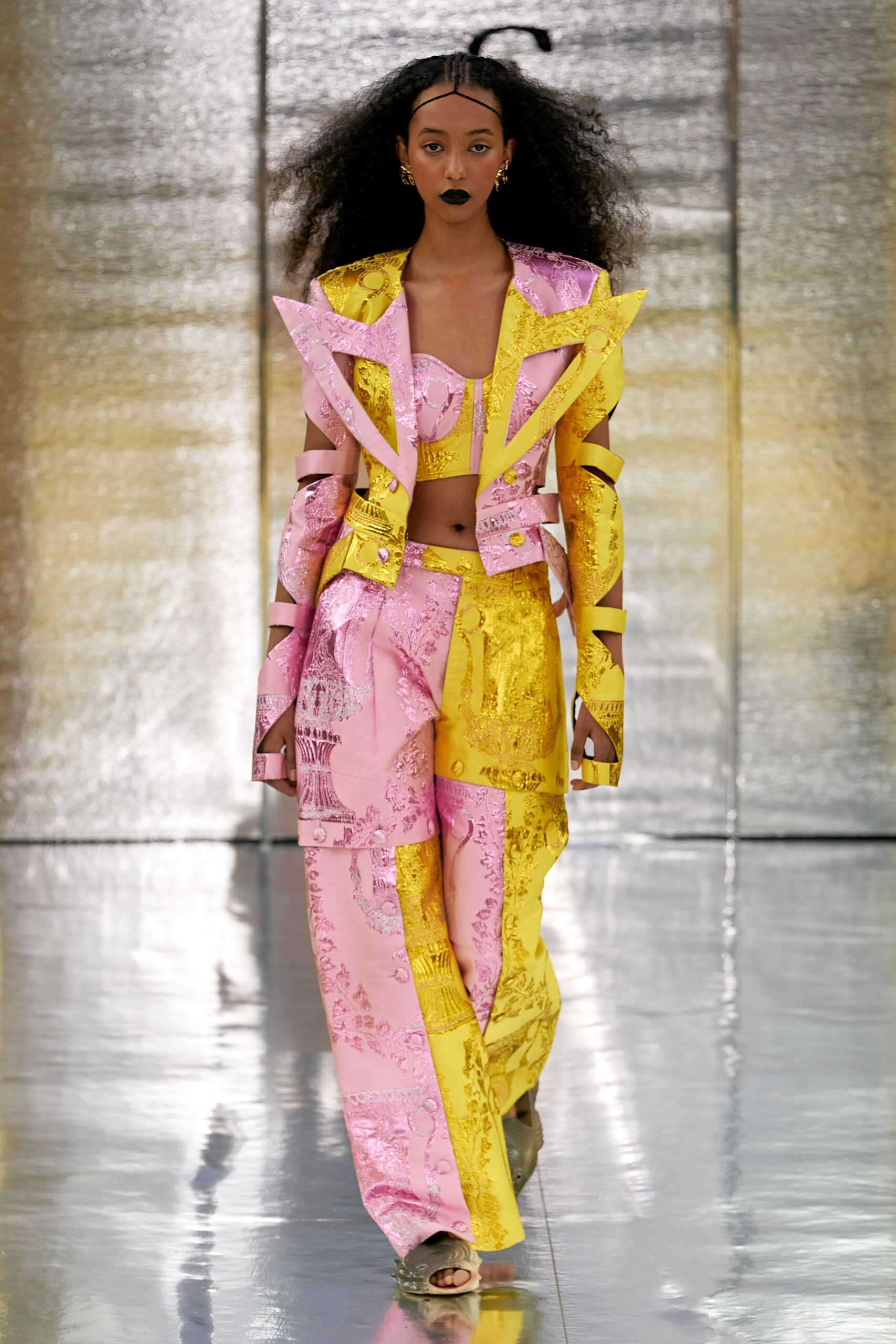 A relaxed fit pink and yellow printed jacket with long sleeves and matching pants featuring an asymmetric design.