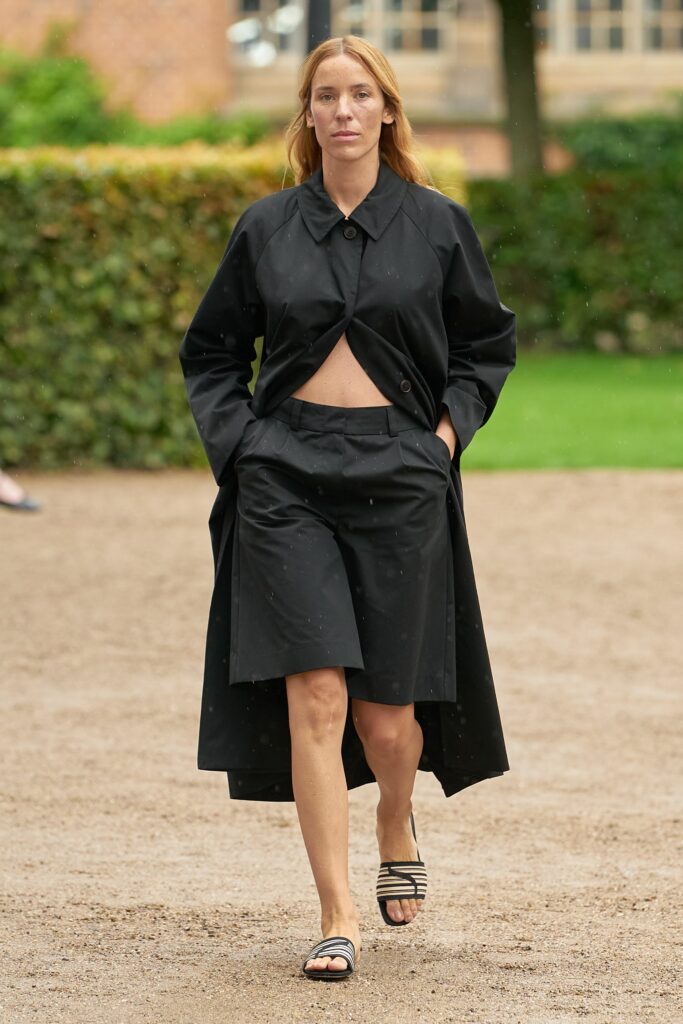 A relaxed black cotton coat paired with an asymmetric skirt for a modern look.