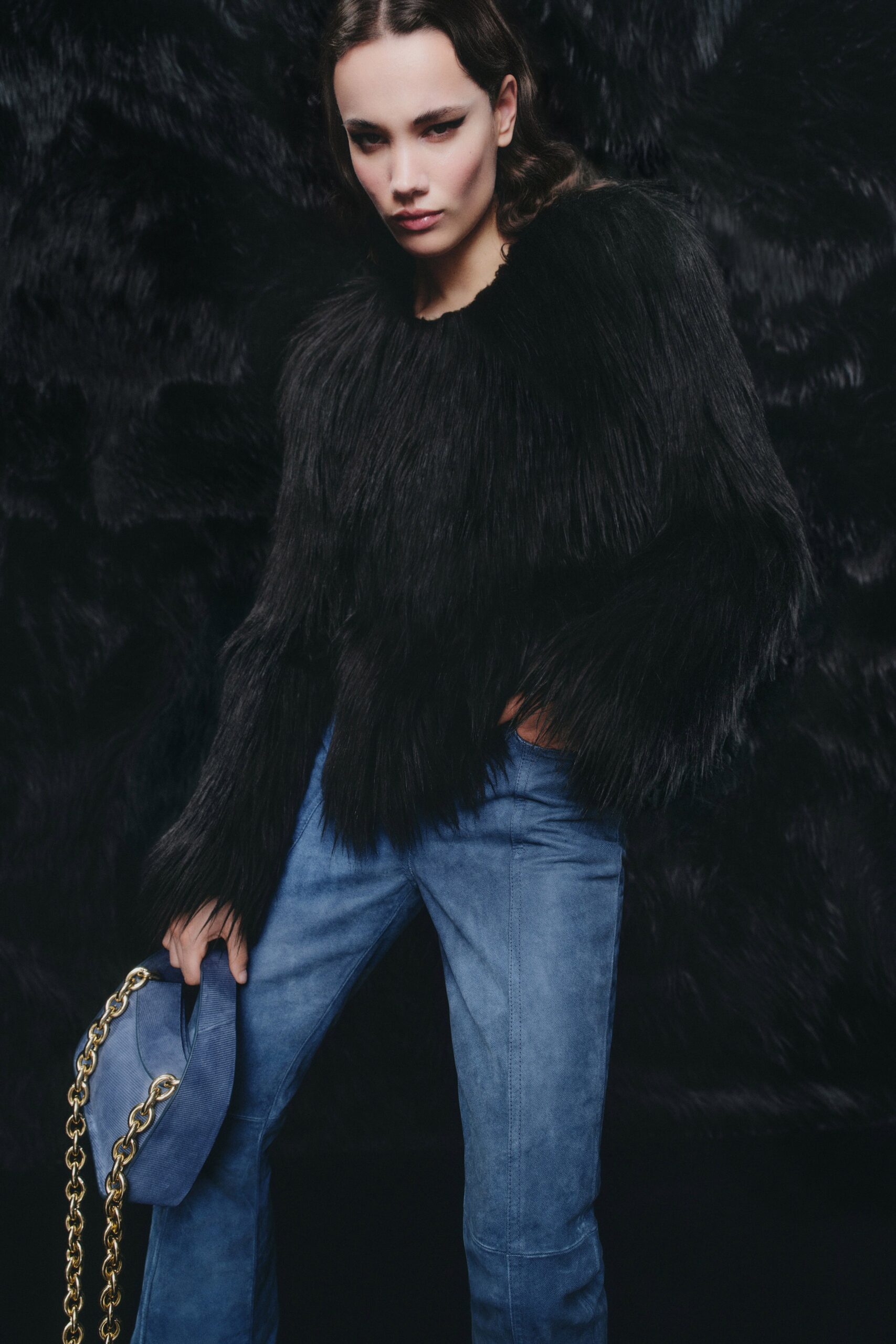 A fitted black fur long-sleeve top paired with blue suede pants.