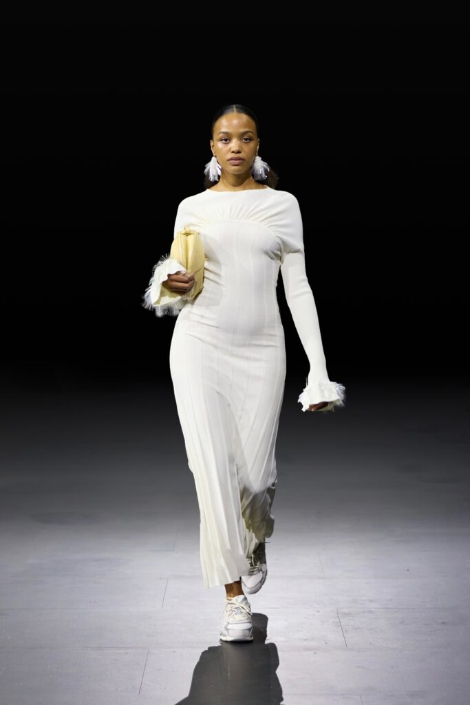 A fitted white long-sleeve dress with a sleek silhouette and elegant design details.