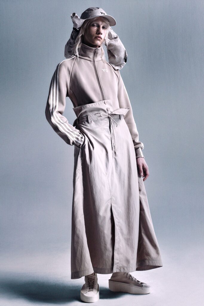 A relaxed beige coat dress with long sleeves, a collared neckline, and an asymmetric belted design.