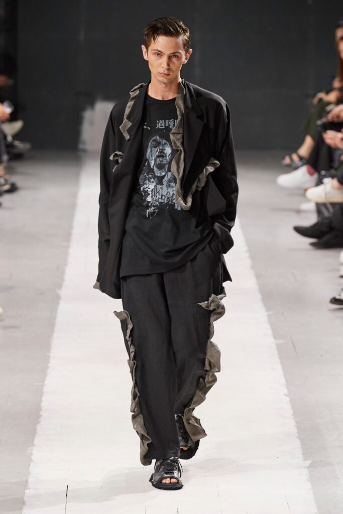 A relaxed black jacket with fringed details paired with matching pants.
