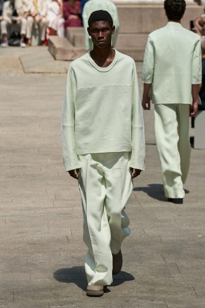 A relaxed cream long-sleeve top paired with straight-leg pants for a modern look.