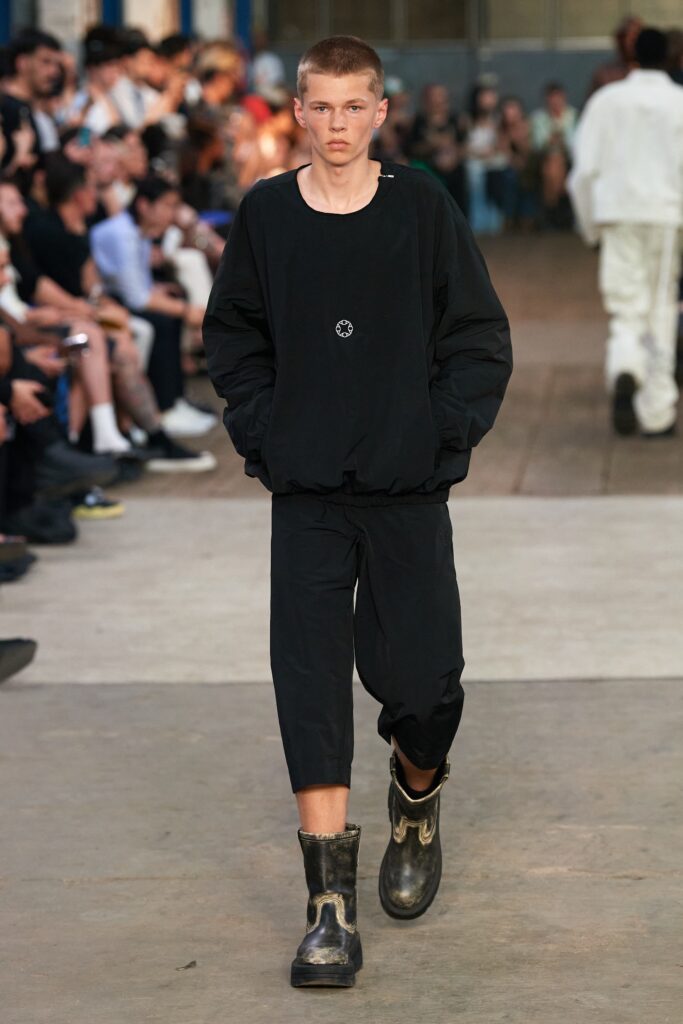 A relaxed black cotton jacket with long sleeves paired with straight-leg pants.