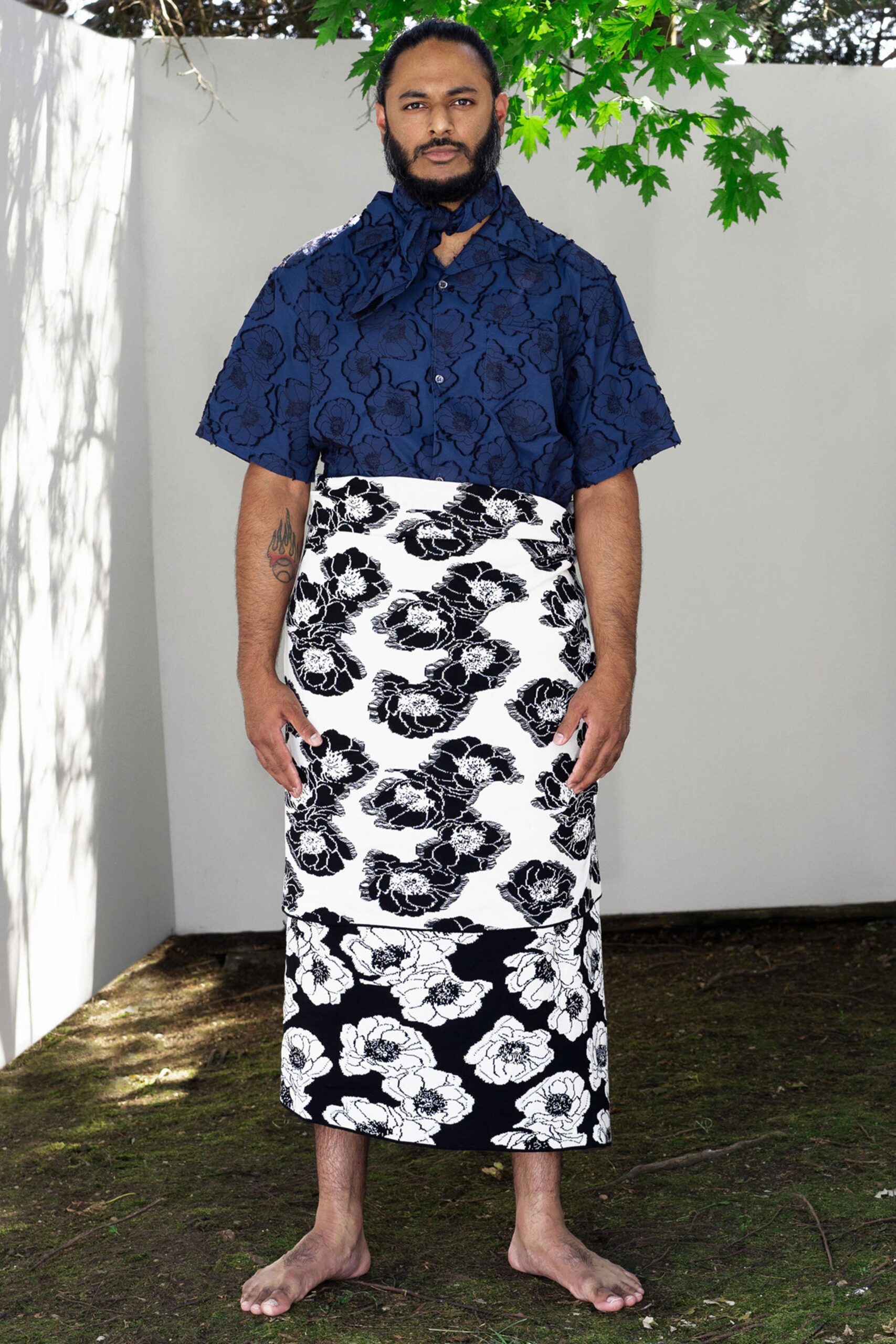 A relaxed blue collared shirt with short sleeves paired with a layered floral skirt.