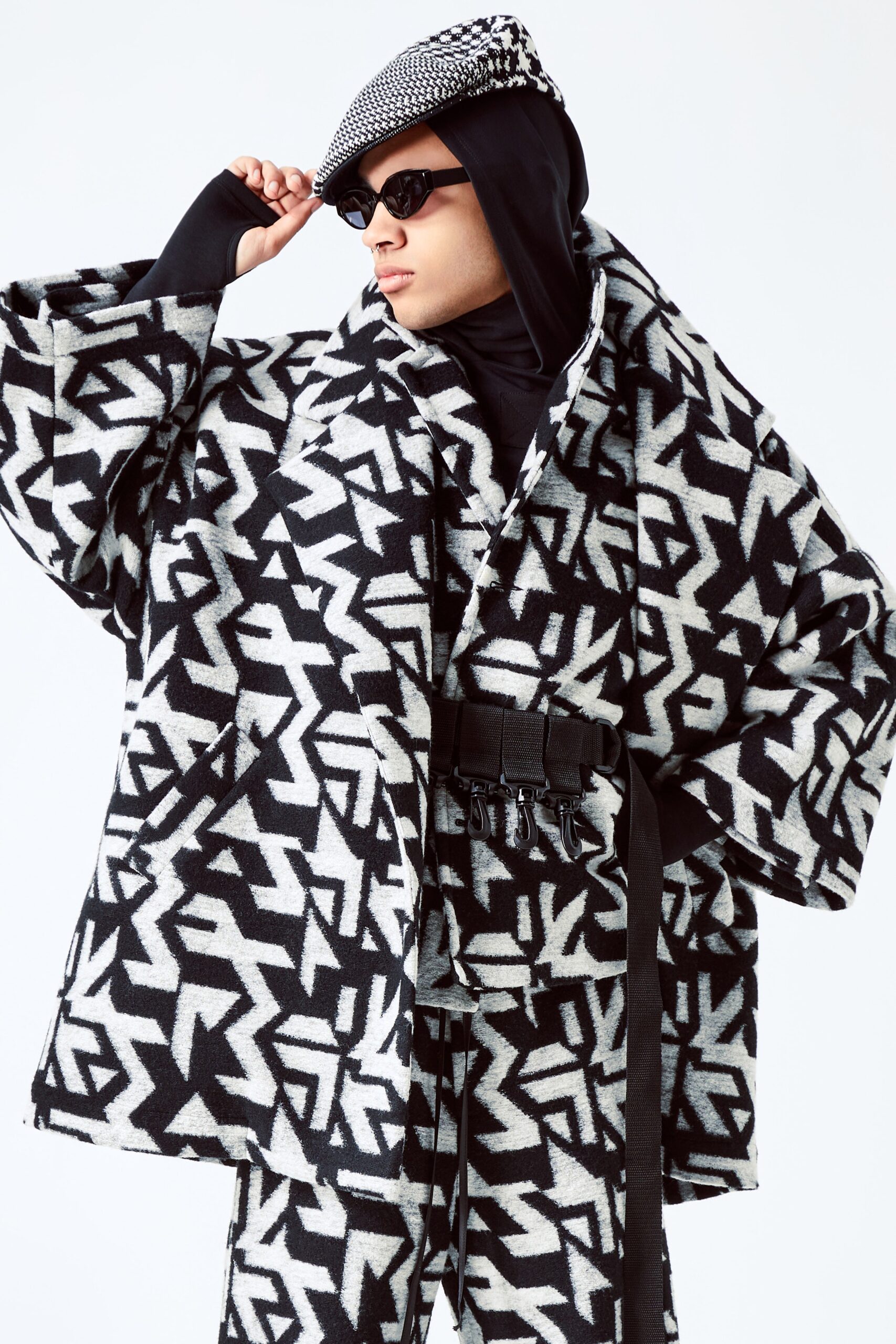 This oversized coat features a striking black and white geometric print that commands attention. The long sleeves and collared design enhance its bold silhouette, while the relaxed fit offers a contemporary edge, making it a standout piece in any wardrobe.