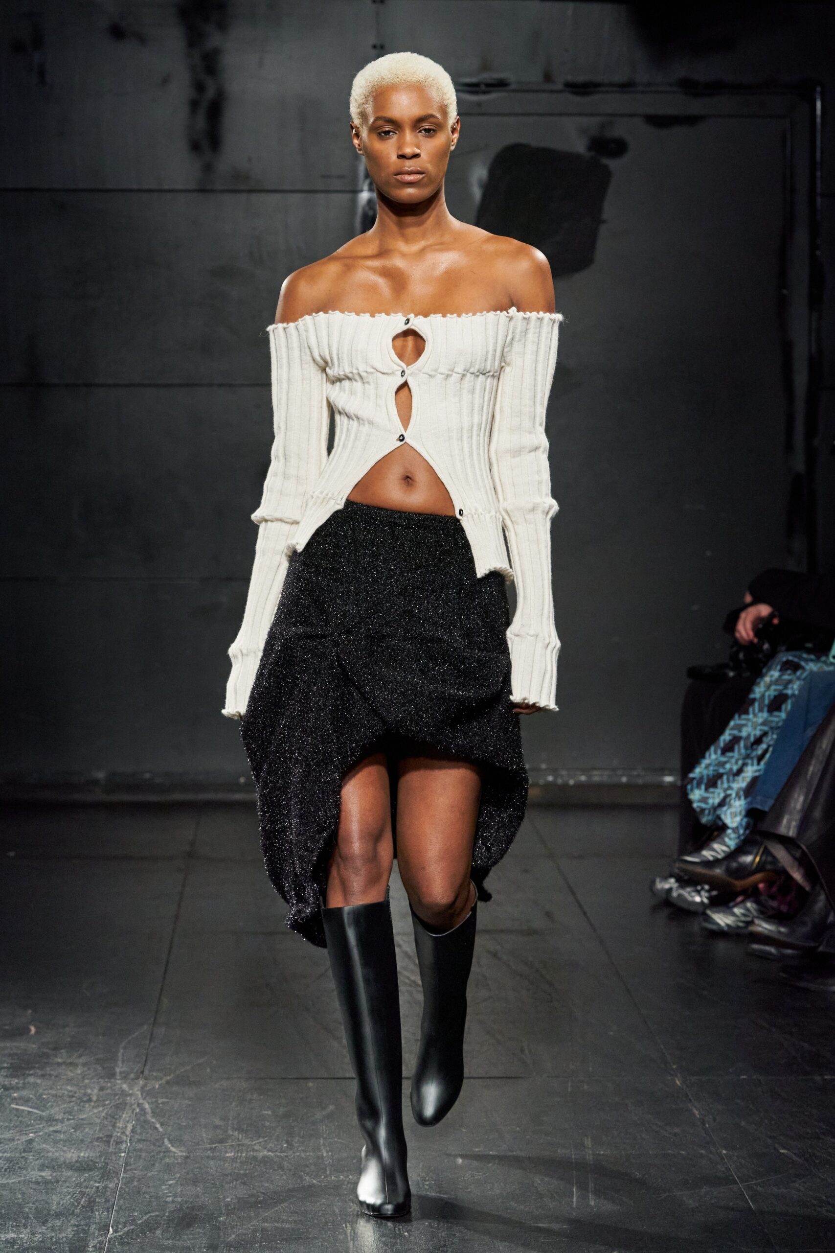 A fitted white off-shoulder top paired with an asymmetric black skirt.