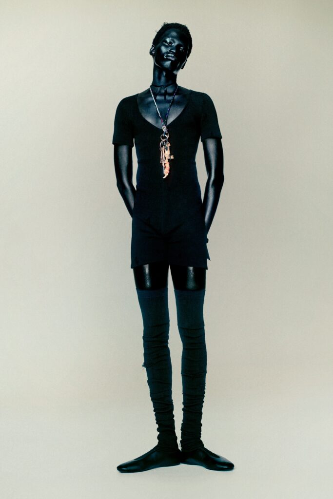 A fitted black mini dress with a V-neckline and short sleeves.