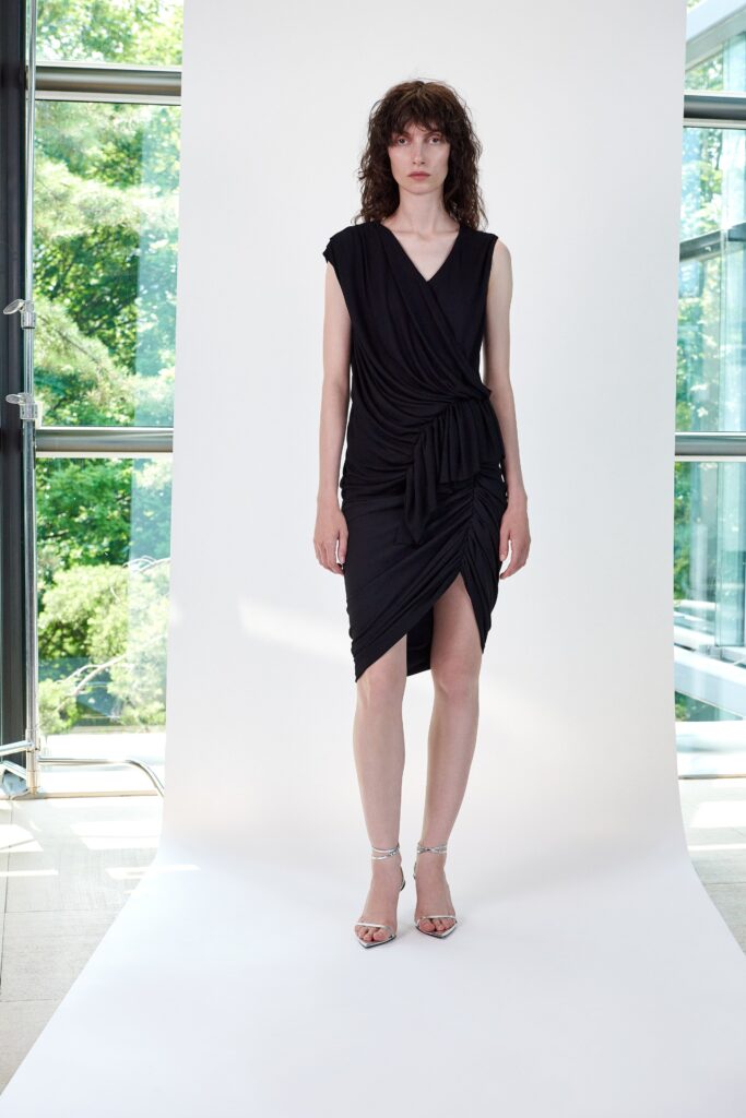 A fitted black sleeveless dress with a V-neckline and wrapped design detail.