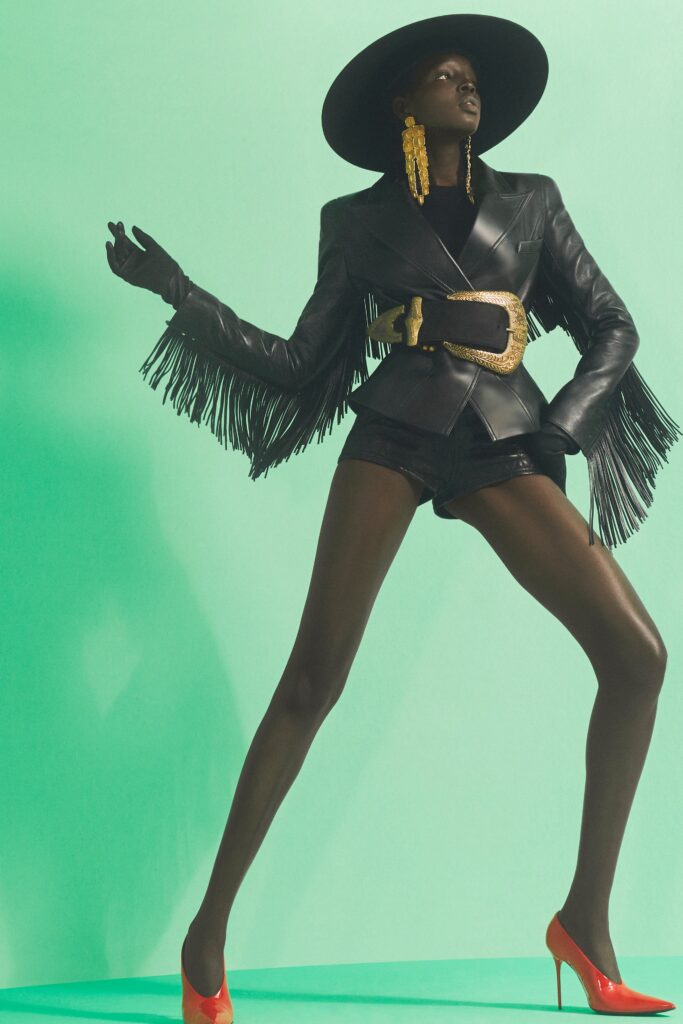 A fitted black leather jacket with fringed details paired with matching shorts.