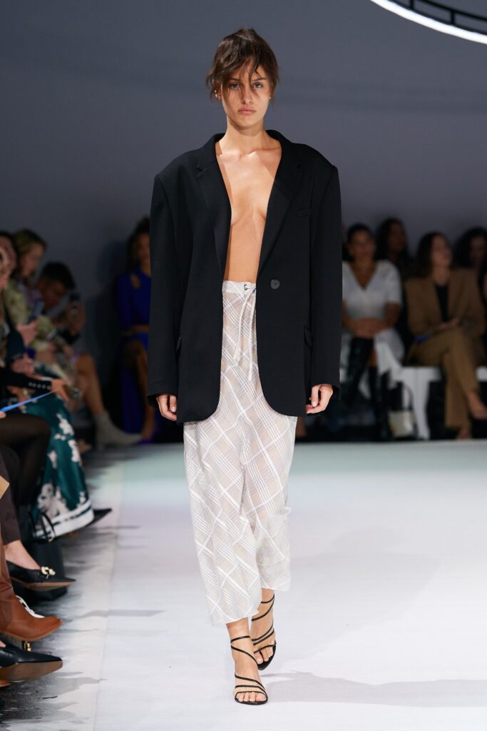 An oversized black blazer paired with a white checked skirt, creating a modern runway look.