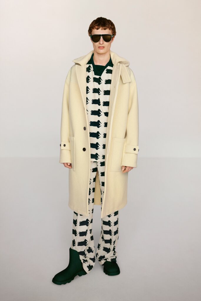 A relaxed beige wool coat paired with black printed pants featuring a unique design.