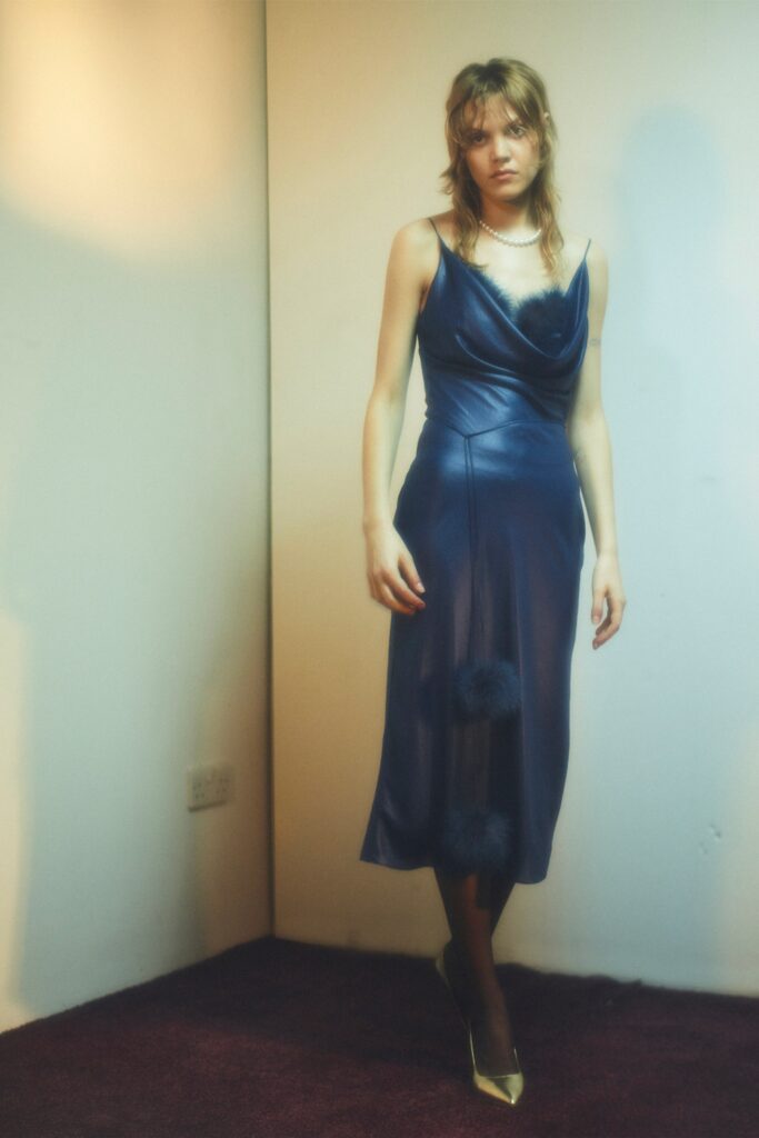 A fitted blue silk dress with a sleeveless design and draped detailing.