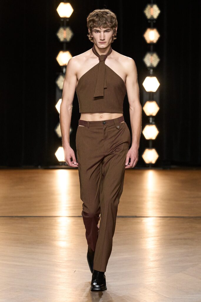A fitted brown striped sleeveless top paired with fitted pants, showcasing a modern silhouette.