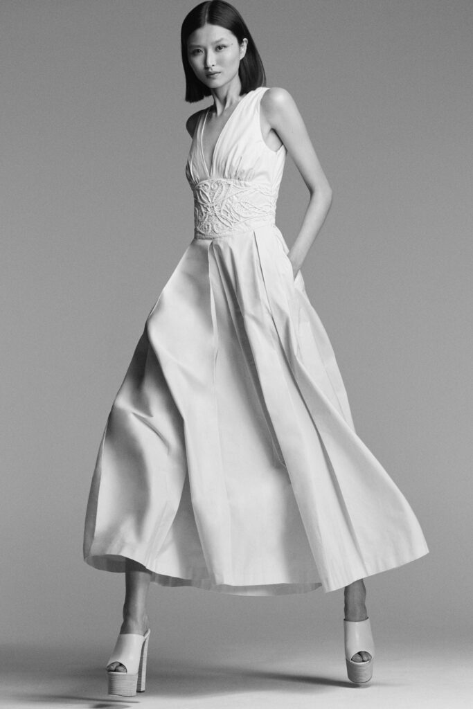 A fitted white sleeveless dress with a V-neckline and A-line silhouette.