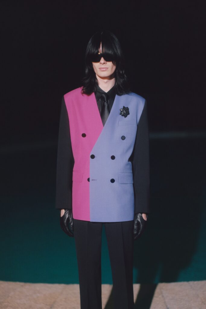 A tailored color-blocked blazer paired with black pants, featuring long sleeves and a collared design.