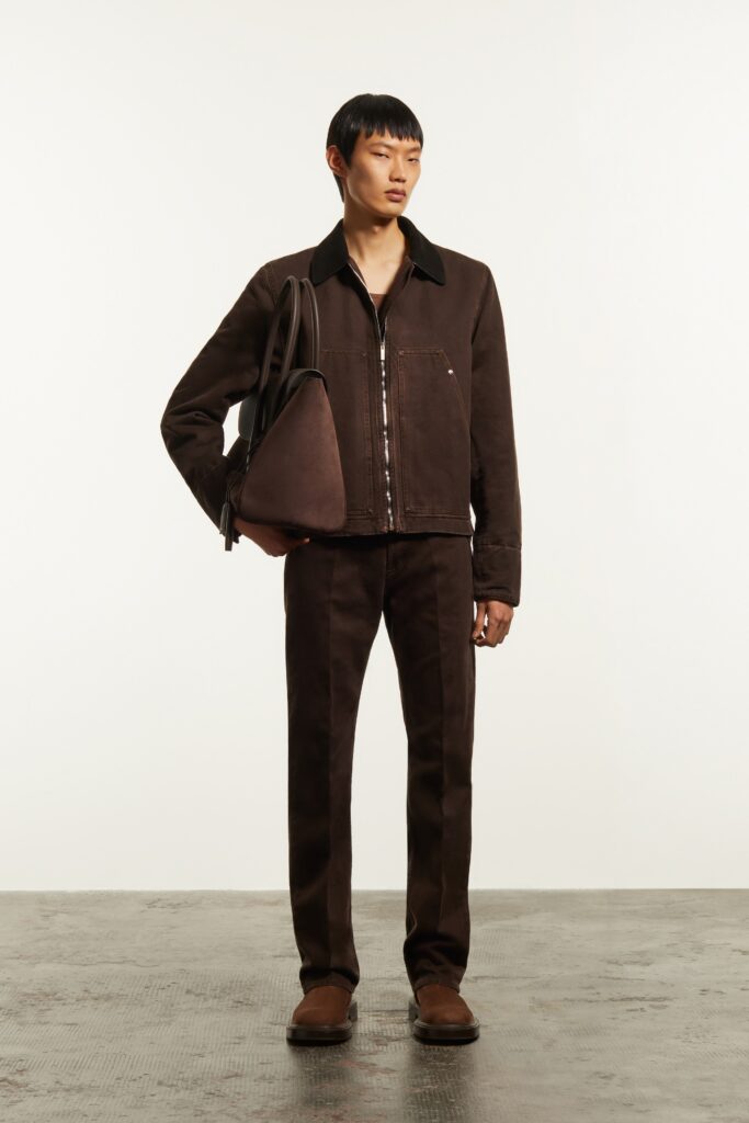 A fitted brown denim jacket with long sleeves and a collared neckline paired with straight-leg pants.