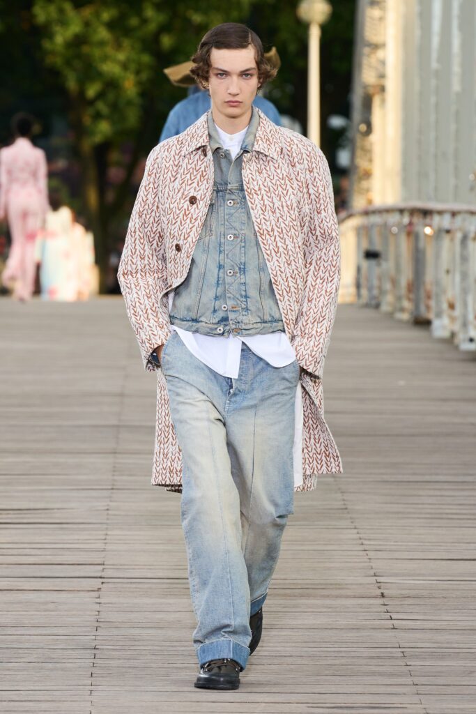 A relaxed-fit beige coat layered over a blue denim vest with a collared design.