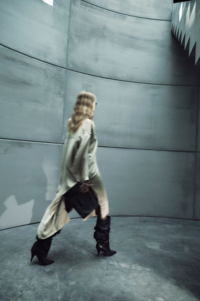A relaxed beige silk dress with long sleeves and an asymmetric design.