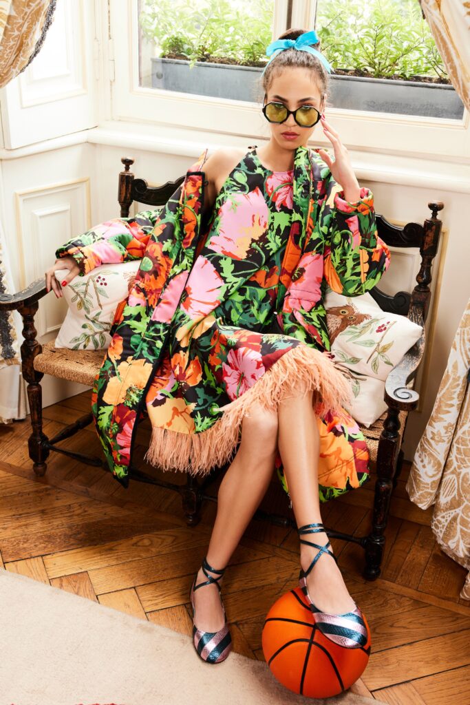 A fitted multicolor sleeveless dress paired with a vibrant coat featuring a fringed hem.