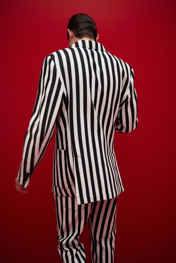 A tailored black and white striped suit with long sleeves and a collared design.