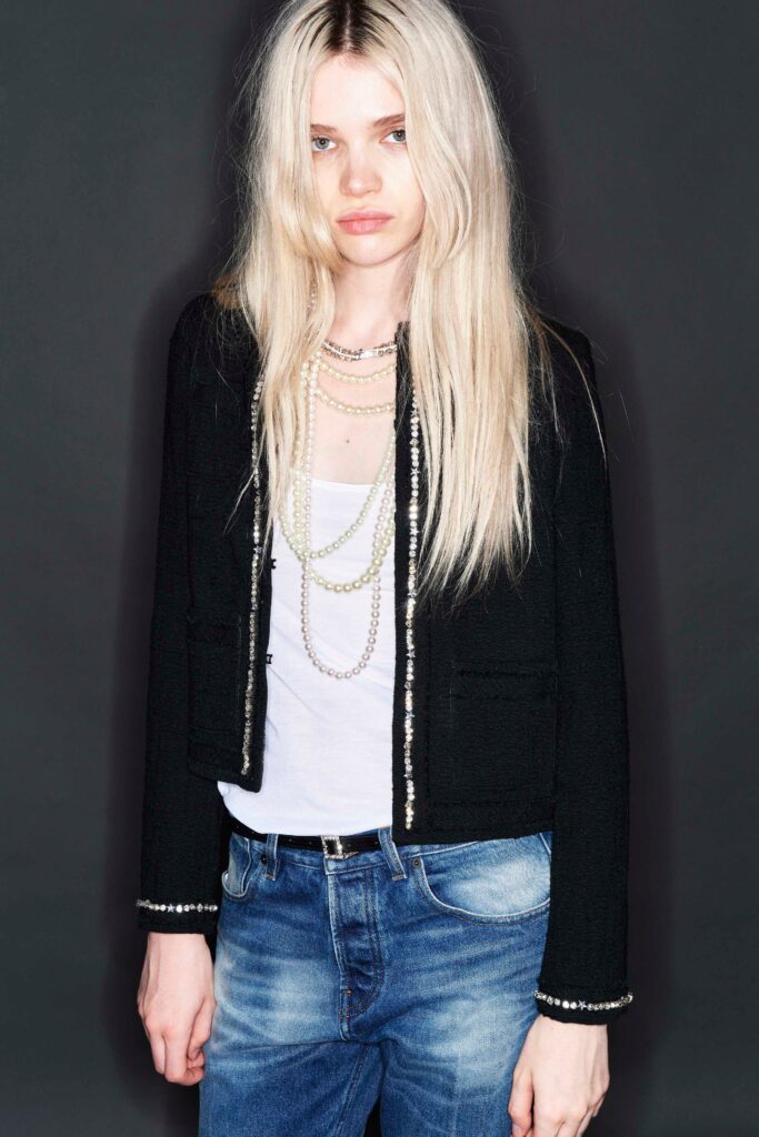 A fitted black jacket paired with a white top and denim jeans, showcasing a stylish casual look.