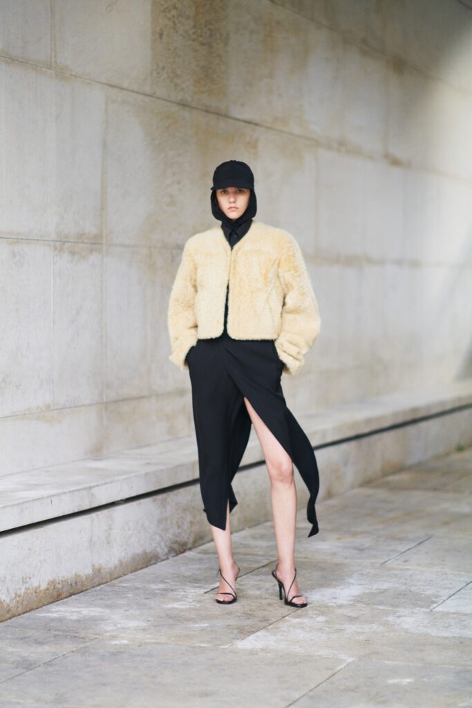 beige faux-fur jacket and black silk skirt