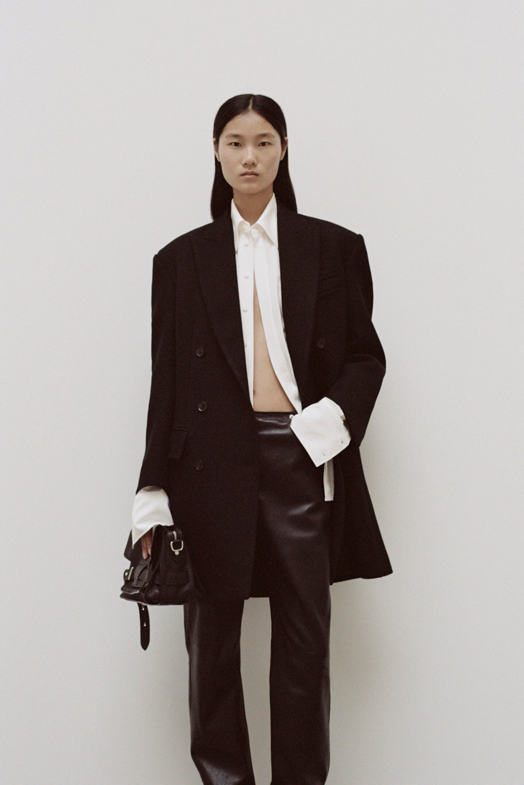 A fitted black blazer with a collared white shirt and straight-leg black pants.
