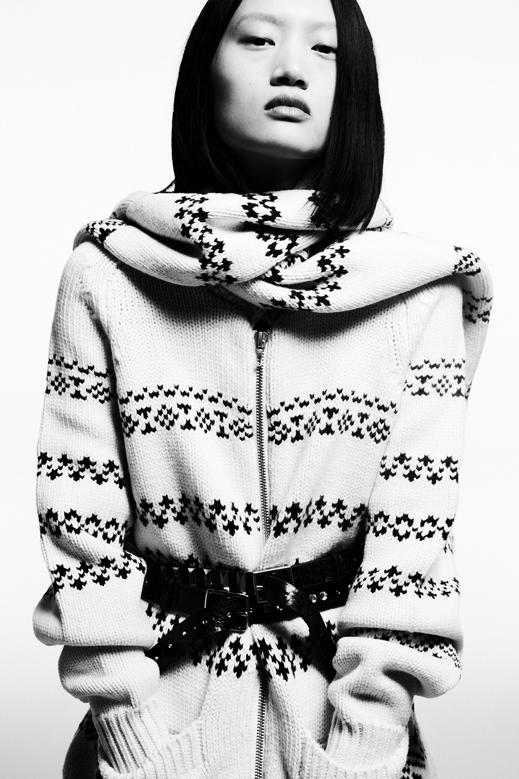 A fitted white sweater with black stripes and a collared design, featuring long sleeves.