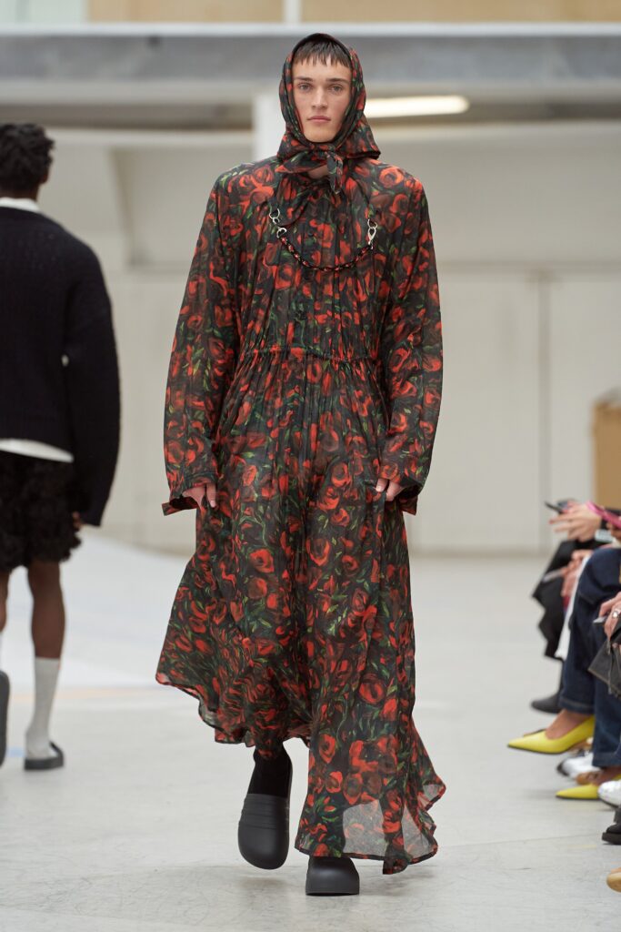 A relaxed floral dress in green and red with long sleeves and a hood.