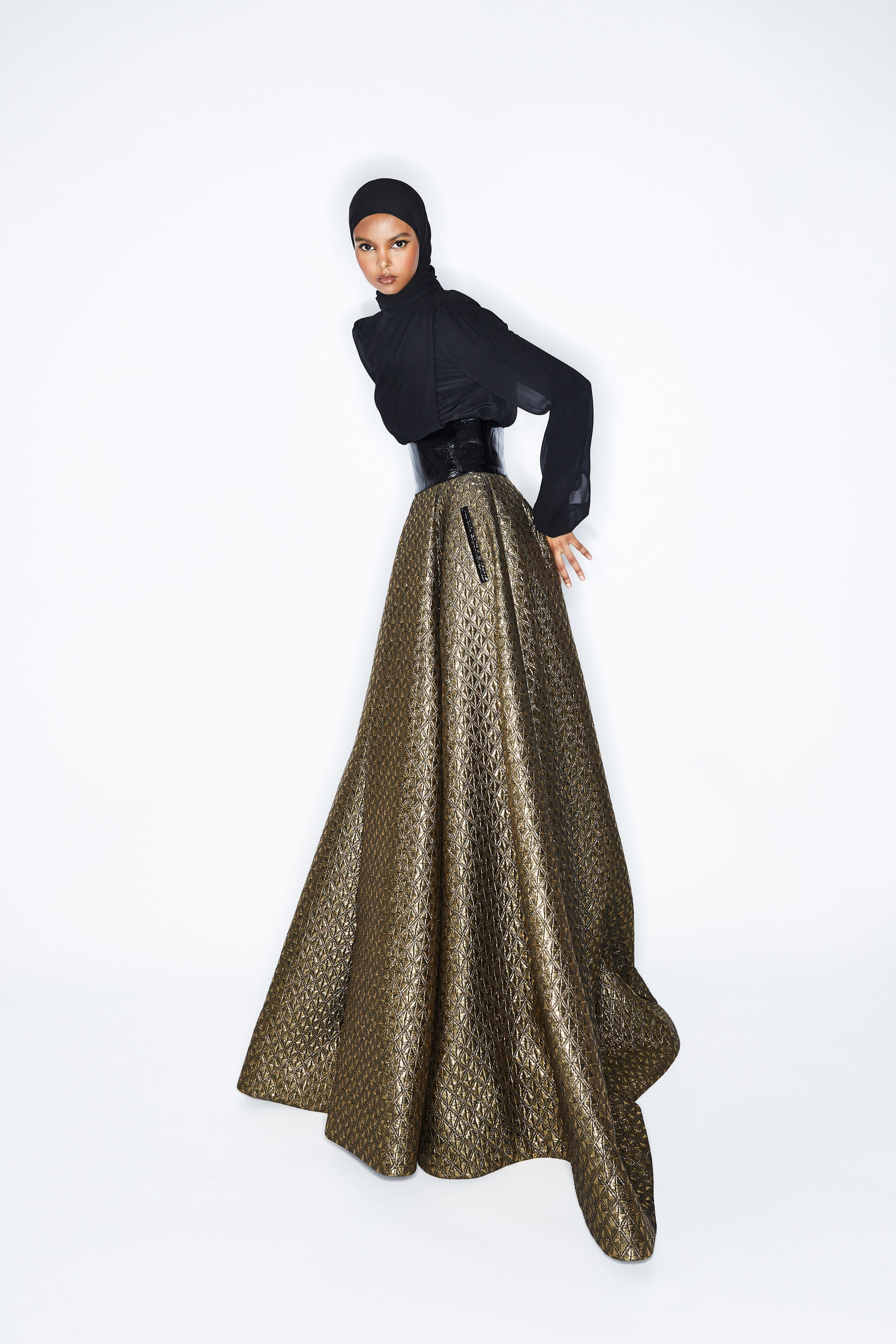 A fitted black and gold silk dress with long sleeves and a high-neck design in an A-line silhouette.