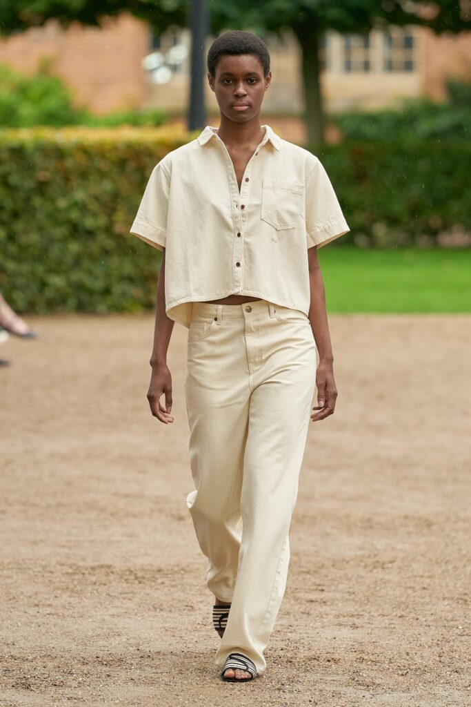 A relaxed beige cotton short-sleeve shirt paired with straight-leg pants for a casual look.