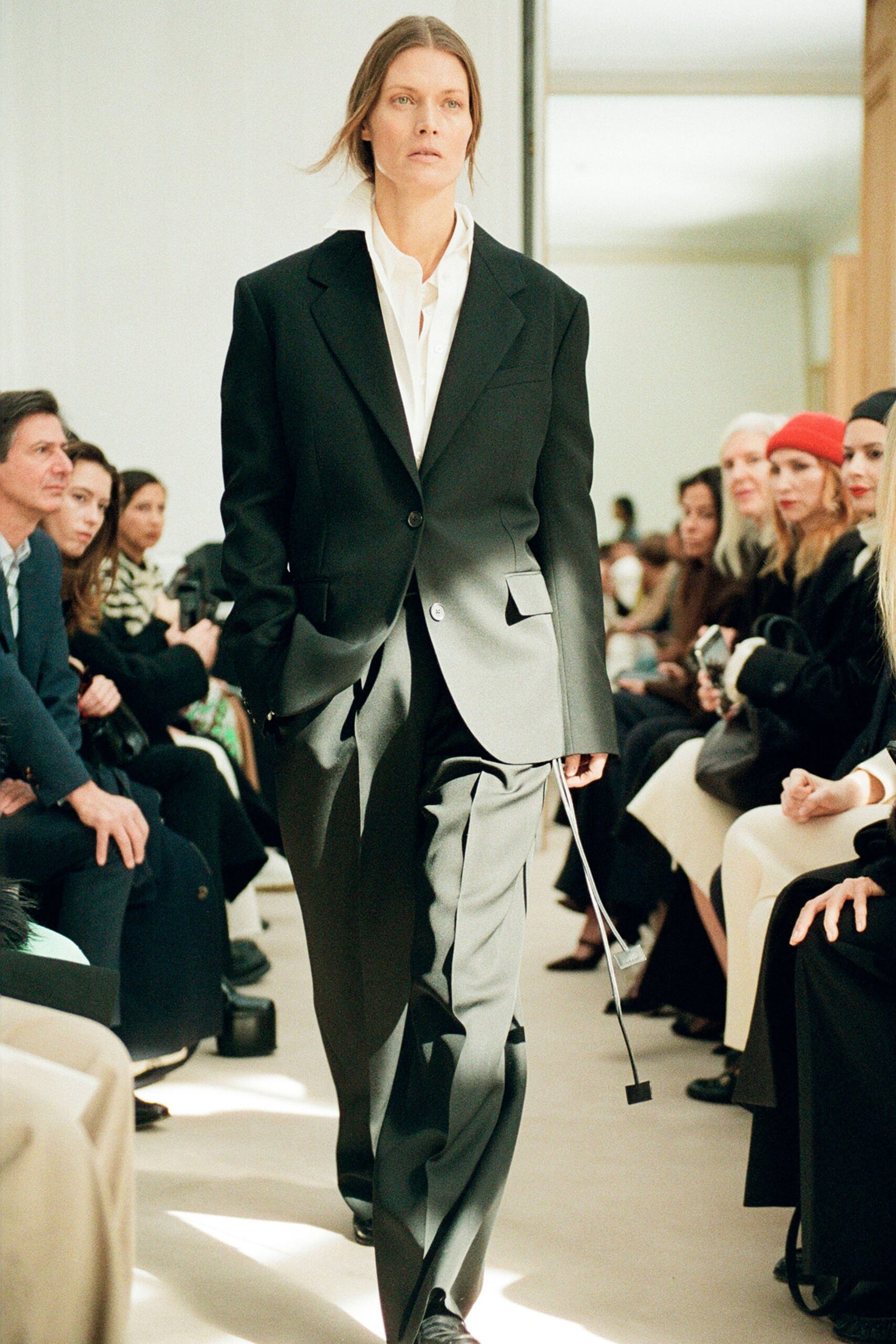 A tailored black wool suit featuring a long-sleeve collared shirt and straight-leg trousers.