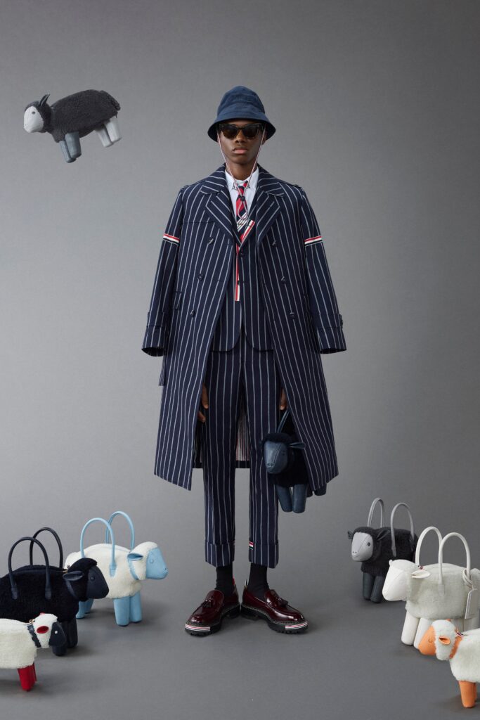 A structured blue striped coat worn over a matching suit with a collared shirt.