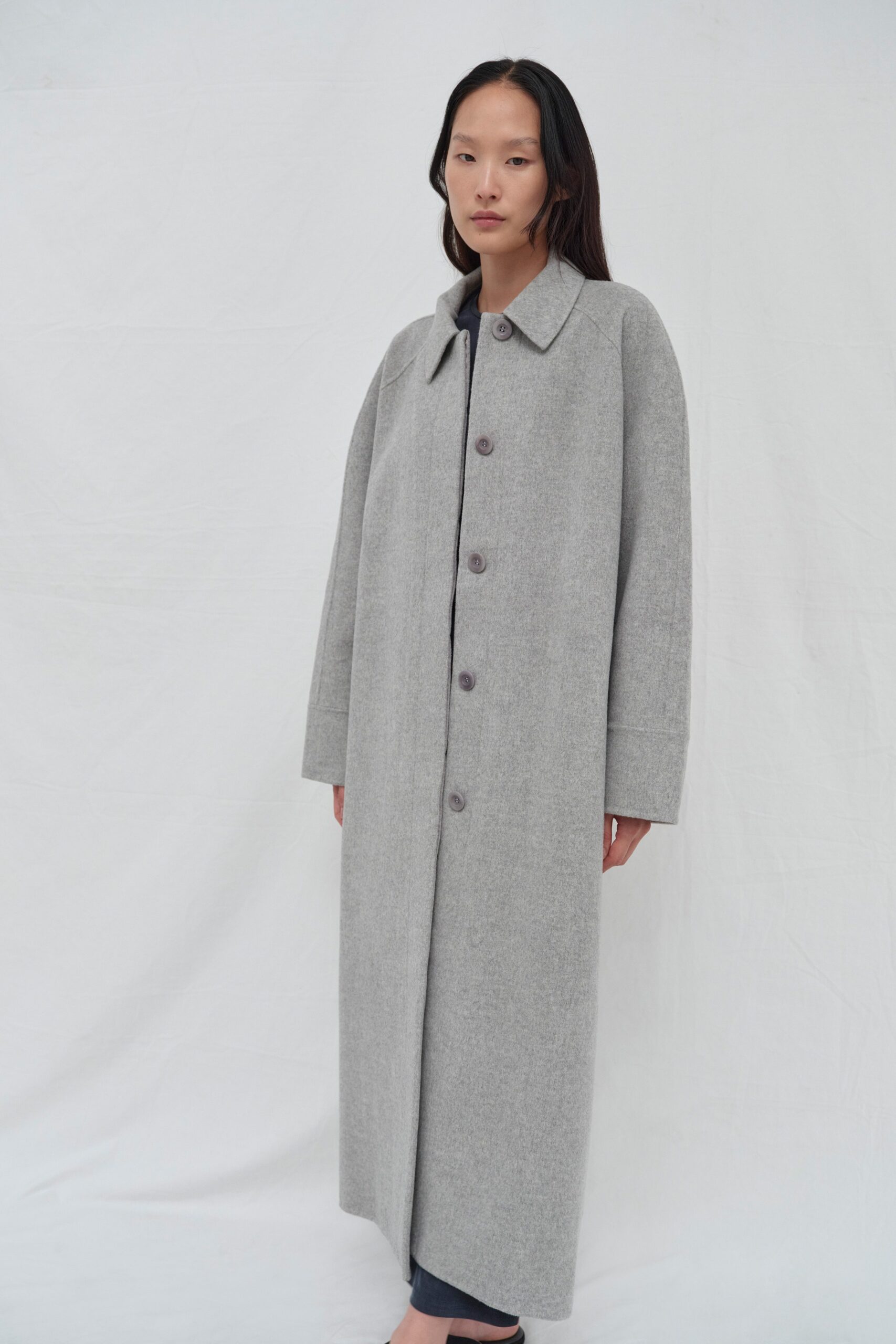 An oversized gray wool coat with a collared neckline and buttoned front.