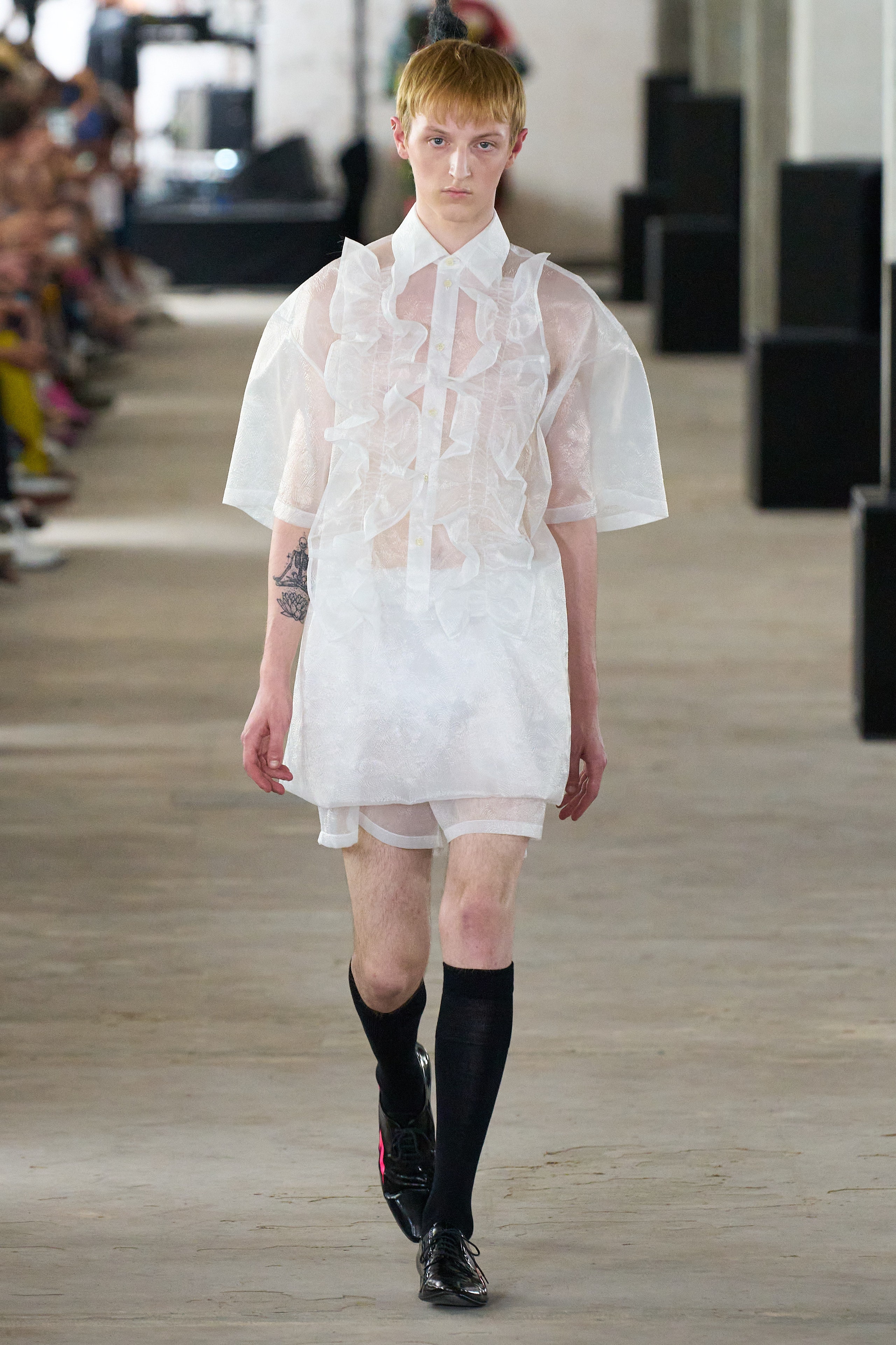 A relaxed white sheer dress with short sleeves and ruffled details.