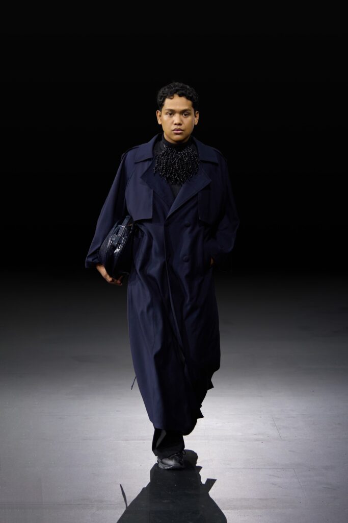 An oversized navy cotton coat with a buttoned front and dramatic collar detail.
