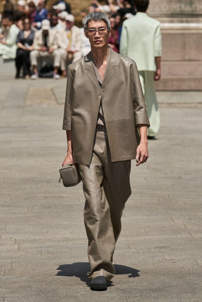 A relaxed beige silk suit with long sleeves and a collared design, featuring straight-leg trousers.