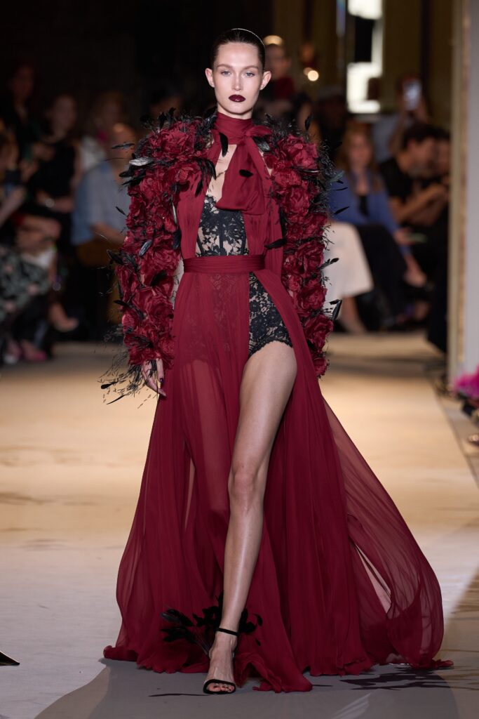 A fitted red silk sleeveless dress featuring a V-neckline and asymmetric layered design.