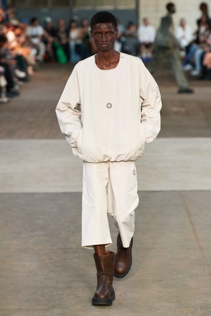 A relaxed white cotton jacket with long sleeves paired with straight-leg pants.