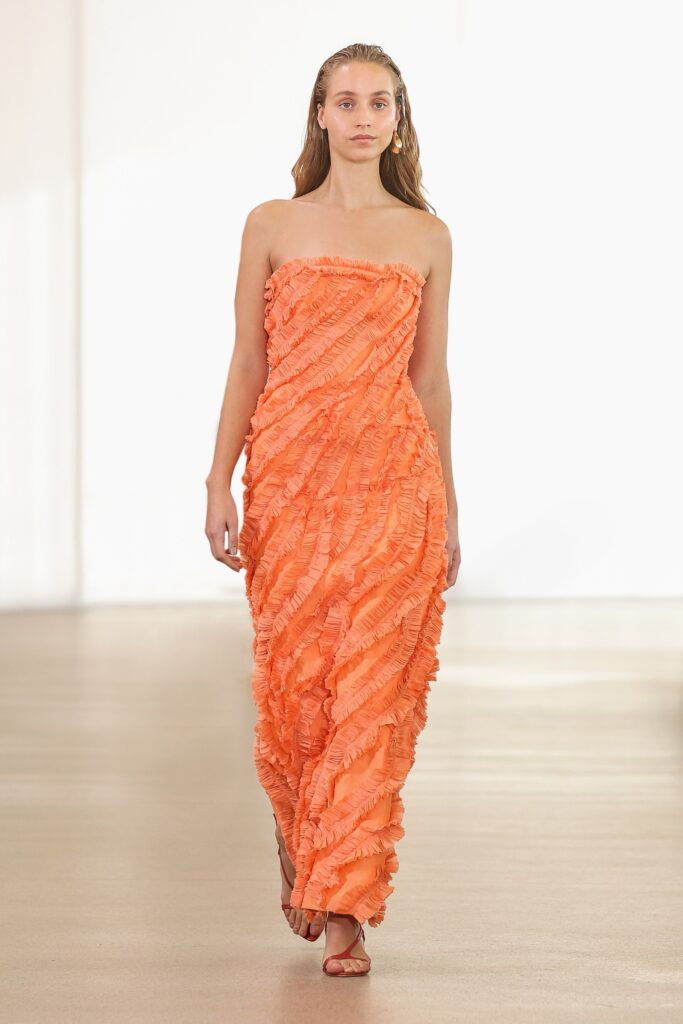 A fitted strapless dress in orange with a ruffled design for a striking look.