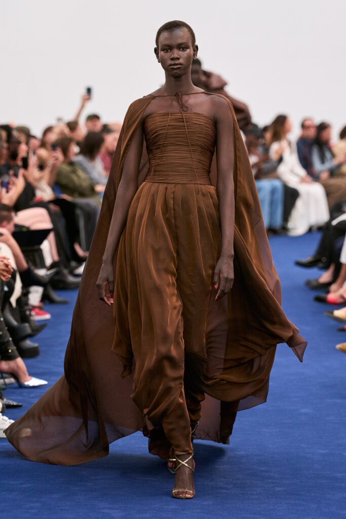 A relaxed brown silk sleeveless dress with a high neckline and draped design.