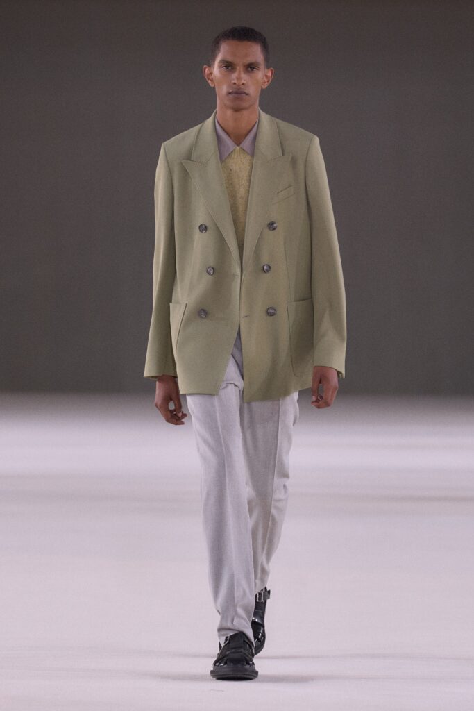 A relaxed green double-breasted blazer paired with gray pants for a modern look.