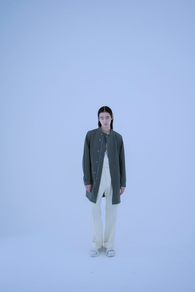 A relaxed gray long-sleeve collared shirt paired with white pants, featuring button details.