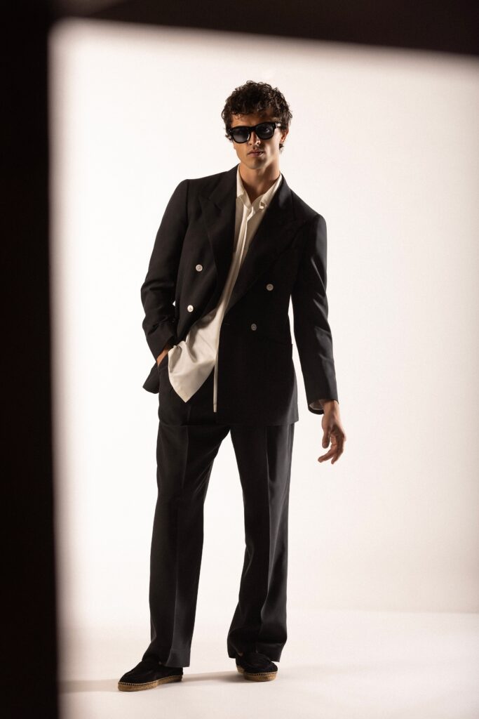 A tailored black suit with a long-sleeve collared shirt and buttoned details.