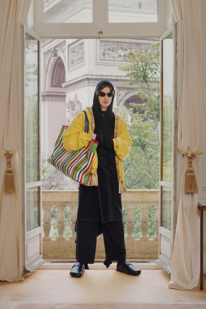 A relaxed black jacket with a hood and layered pants, complemented by a yellow outer layer.