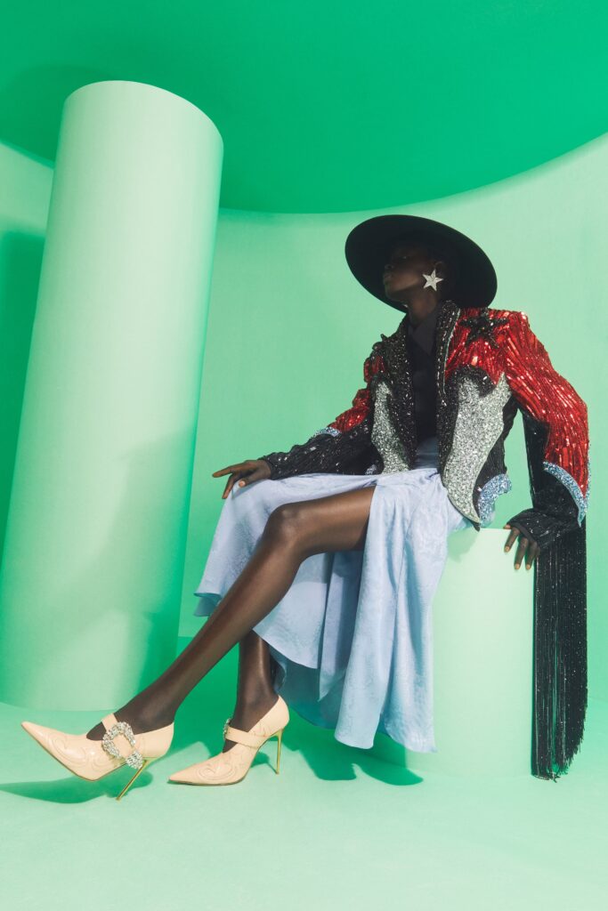 A fitted sequined jacket with long sleeves and a layered asymmetric skirt in a vibrant color palette.