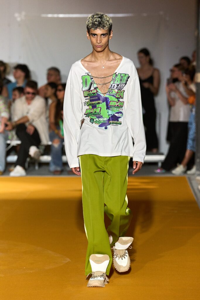 A relaxed white long-sleeve printed shirt paired with green pants for a casual look.