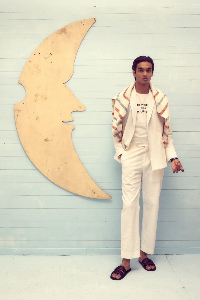 A tailored white suit with long sleeves and a collared shirt, featuring a buttoned design.