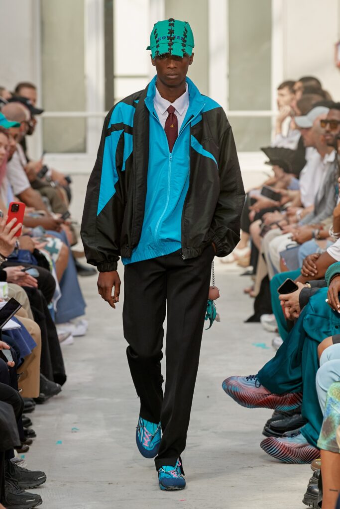 A relaxed blue and black color-blocked jacket paired with black pants.